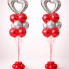 Pair of Valentine’s Day balloon columns with silver heart foil balloons, red and silver latex balloon clusters, and red balloon bases on a neutral background.