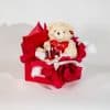 Valentine gift box with teddy bear holding love heart and red rose in glass dome in red and white romantic packaging on a neutral background