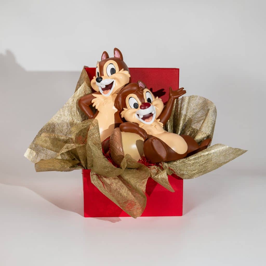 Valentine gift box with cute squirrel couple figurines in elegant red and gold romantic packaging on neutral background