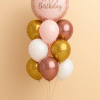 Balloon bouquet with a large blush pink “Happy Birthday” foil balloon, surrounded by gold, rose gold, soft pink, and white latex balloons, all elegantly tied with matching ribbons and arranged on a stylish balloon base.