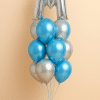 Balloon bouquet featuring a large silver foil “M” balloon with a combination of blue and silver latex balloons, arranged on a mini balloon base. initial letter
