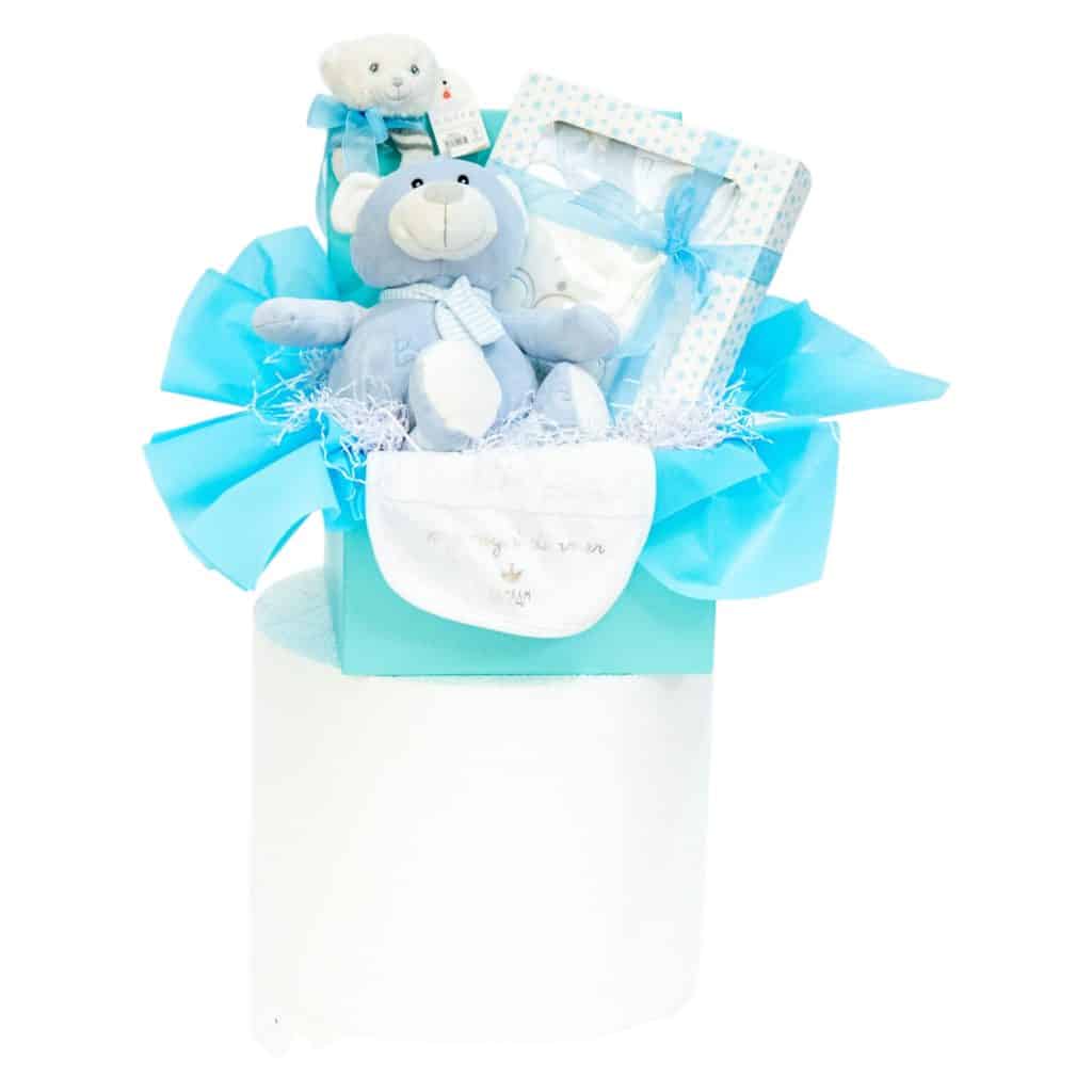 Baby boy gift box featuring a blue bear plush toy, star print baby clothing set, and embroidered bib in a pastel blue box with tissue paper.