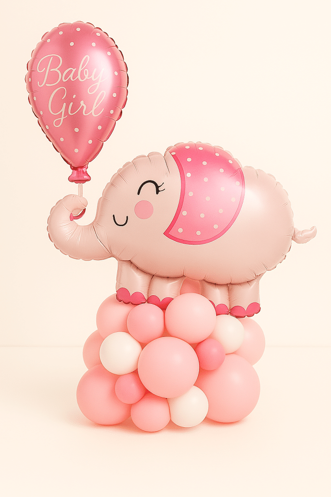 Pink elephant balloon arrangement holding a “Baby Girl” foil balloon, on a soft base of blush, baby pink, ivory, and hot pink latex balloons — perfect for welcoming a newborn girl.