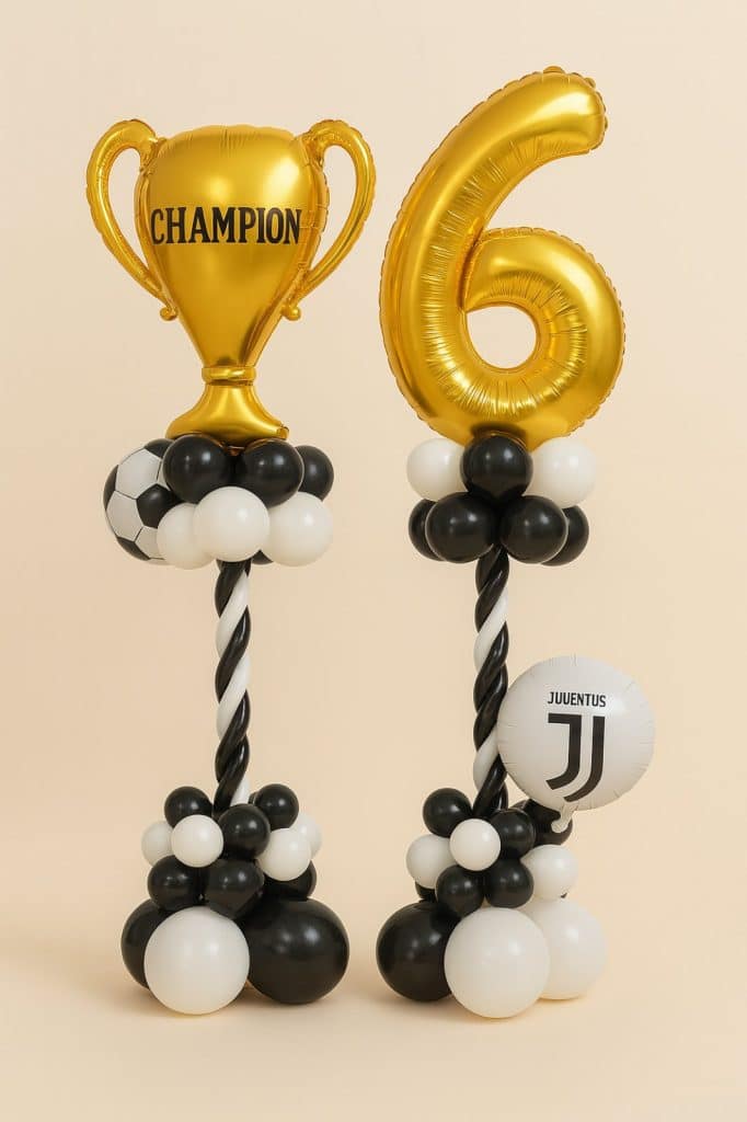 Set of two balloon columns featuring a gold "CHAMPION" trophy foil and a number 6 balloon, complemented by soccer and Juventus-themed balloons on twisted black-and-white pillars and black-white balloon bases.