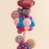 Balloon column with a large pink Troll foil balloon on top, surrounded by birthday message balloons, and a twisted pink spiral base decorated with balloons in pink, purple, red, and turquoise tones.