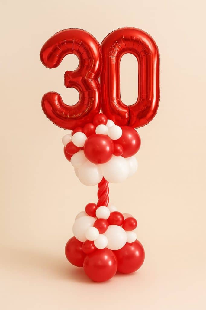 Balloon column featuring large red foil number balloons “3” and “0” on a red and white base with a twisted red balloon stem.