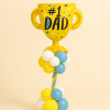Balloon tower with yellow “#1 Dad” trophy foil balloon on a yellow, sky blue, and white twisted balloon column and base.