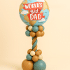 Balloon tower with “World’s Best Dad” foil globe balloon on a teal, gold, and ivory twisted balloon column and base.