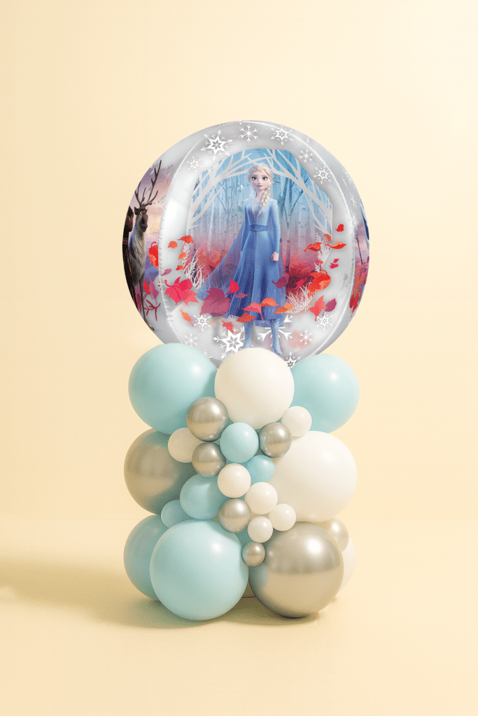 Frozen-themed balloon tower with Elsa bubble foil balloon and latex balloons in icy blue, silver, and white, arranged in a clustered snow effect.