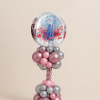 Frozen-themed balloon tower with Elsa bubble foil balloon, metallic pink and silver latex balloons in a twisted tower design with clustered base.