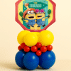 Minions themed birthday balloon table centrepiece with yellow blue and red balloon base and large character foil balloon on neutral background