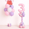 Peppa Pig birthday balloon duo with pastel pink number twisted column and matching pink and lavender latex bouquet in neutral studio background