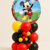 Mickey Mouse foil balloon tower with red, yellow, and black latex balloon base and decorative mini balloon cluster on a neutral background.