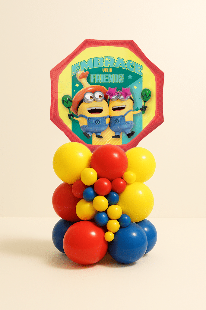Minions Friends foil balloon table centerpiece with layered red, yellow and blue latex balloon base on a neutral background.