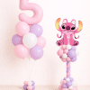 Pink Angel Stitch foil balloon on a pastel pink, lavender, and white twisted balloon column with decorative balloon base on a neutral background.