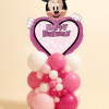 Minnie Mouse Happy Birthday heart foil balloon mounted on an organic pink and white latex balloon centerpiece with mixed balloon sizes on a neutral background.