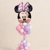 Minnie Mouse head foil balloon on a pastel pink, lavender, and white twisted spiral balloon column with organic balloon clusters on a neutral background.