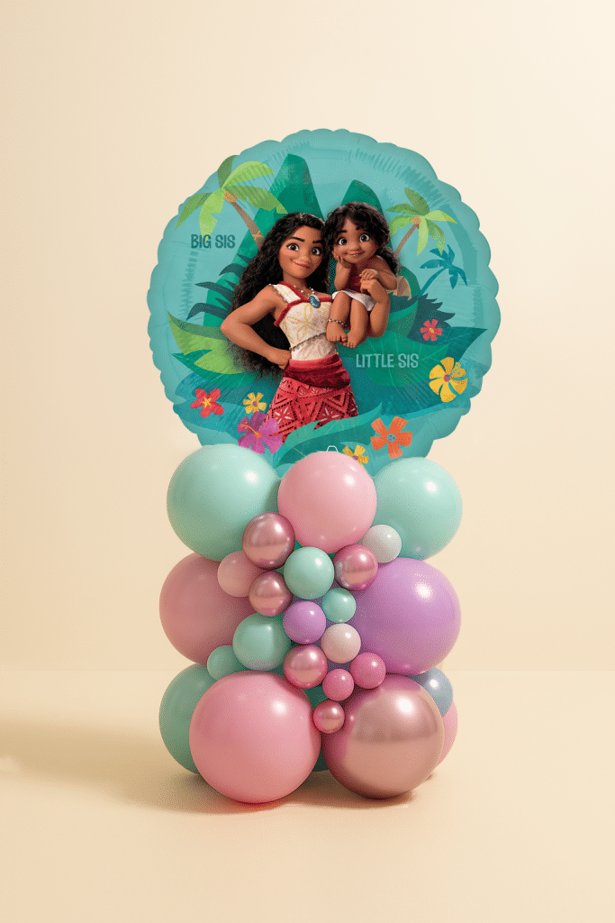 Round Moana Big Sis Little Sis foil balloon on a pastel mint, pink, lilac, and chrome rose gold organic balloon base on a neutral background.