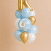 Personalised initial balloon bouquet with It's a Boy foil balloon and soft blue, white and metallic gold latex balloons.