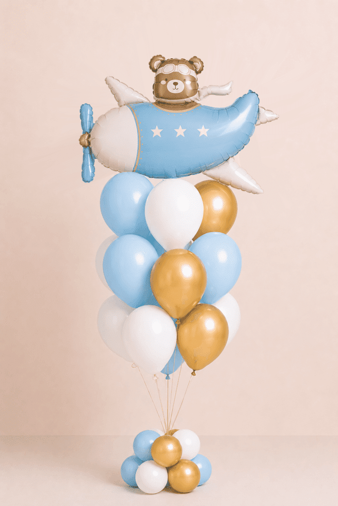 Bear pilot airplane balloon bouquet with blue, white and gold helium balloons on a matching balloon base.