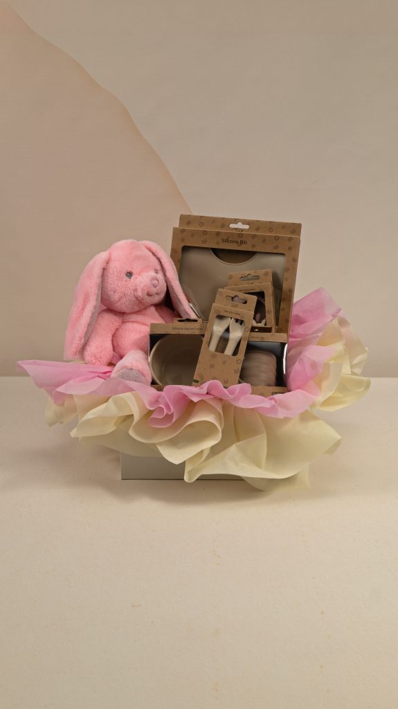 Pink baby girl gift box with Keel Toys bunny and AMEK Toys silicone bib, vacuum bowl, cup, cutlery and teether, beautifully presented in pink and cream wrapping.