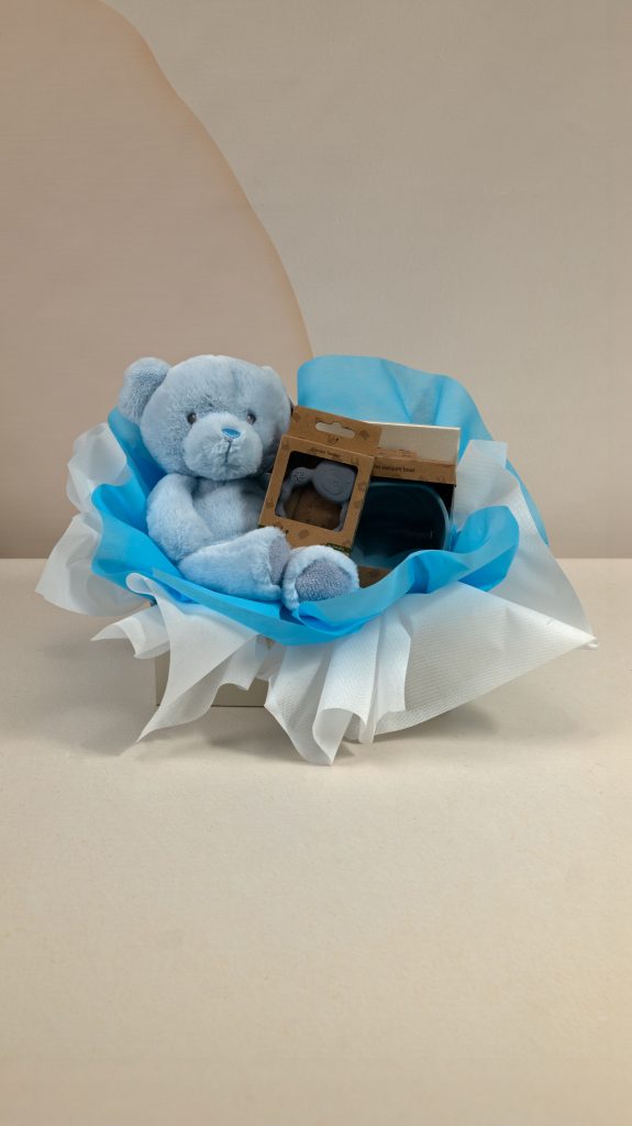 Baby boy gift box with blue Keel Toys teddy bear, AMEK Toys silicone vacuum bowl and silicone teether, presented in blue and white wrapping.