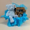 Deluxe baby boy gift box with blue Keel Toys teddy bear and AMEK Toys silicone plate, cup, cutlery and assorted teethers in blue gift wrapping.