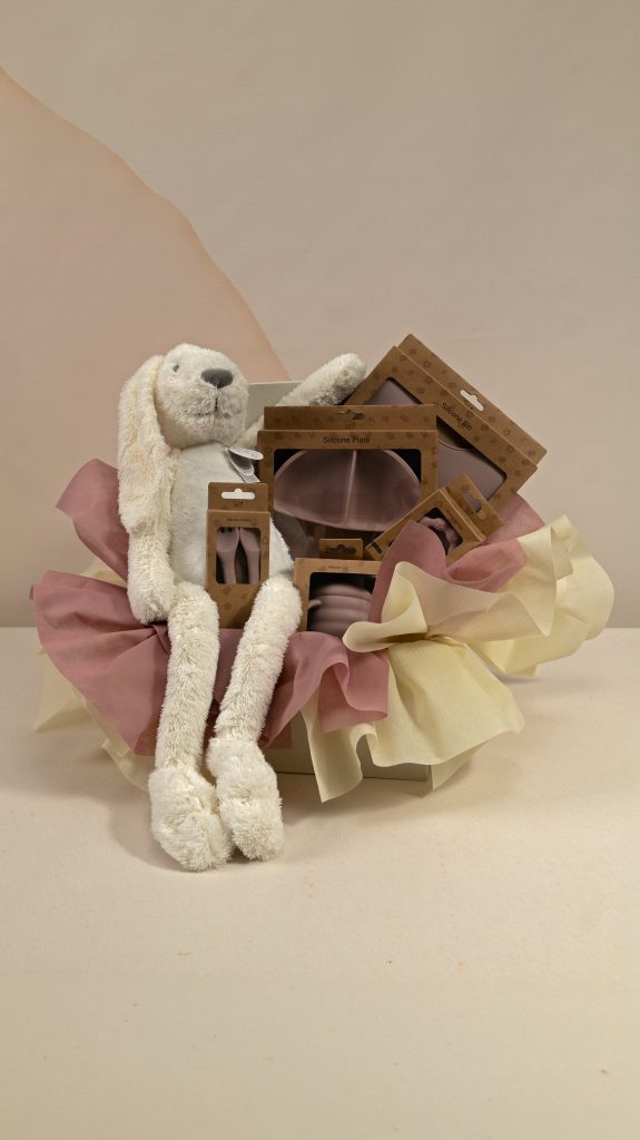 Ivory bunny baby gift box with blush silicone divided plate, bib, cup, cutlery and teether, presented with blush and ivory wrapping.